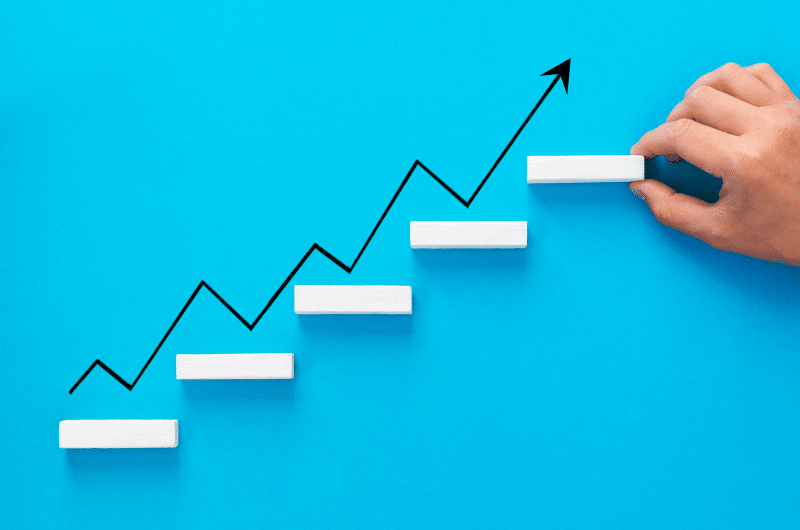 f7b51dda businessman arranging wooden blocks stacking as step stair with growth arrow 1